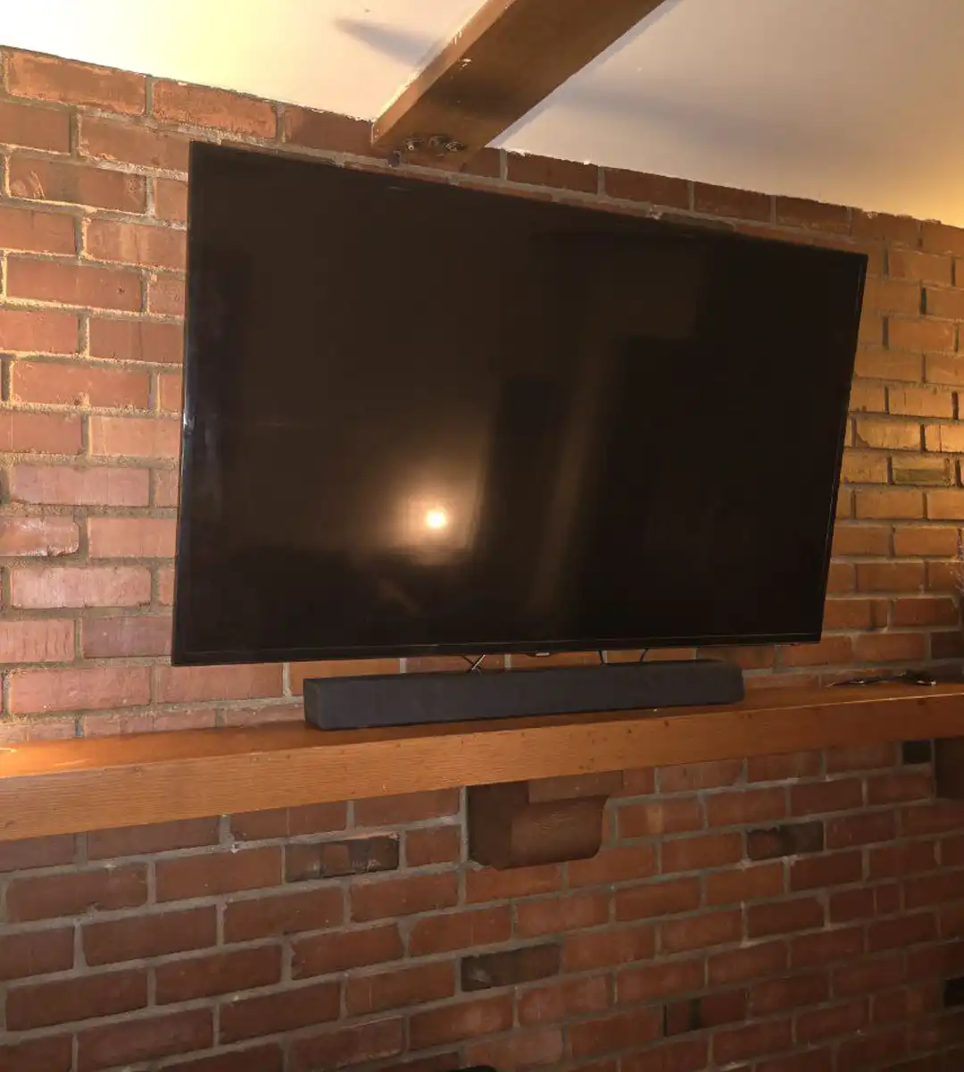 TV Installation on Antique Brick Wall Above Fireplace